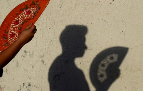 A woman uses a fan to keep cool as a heatwave continues in Madrid.