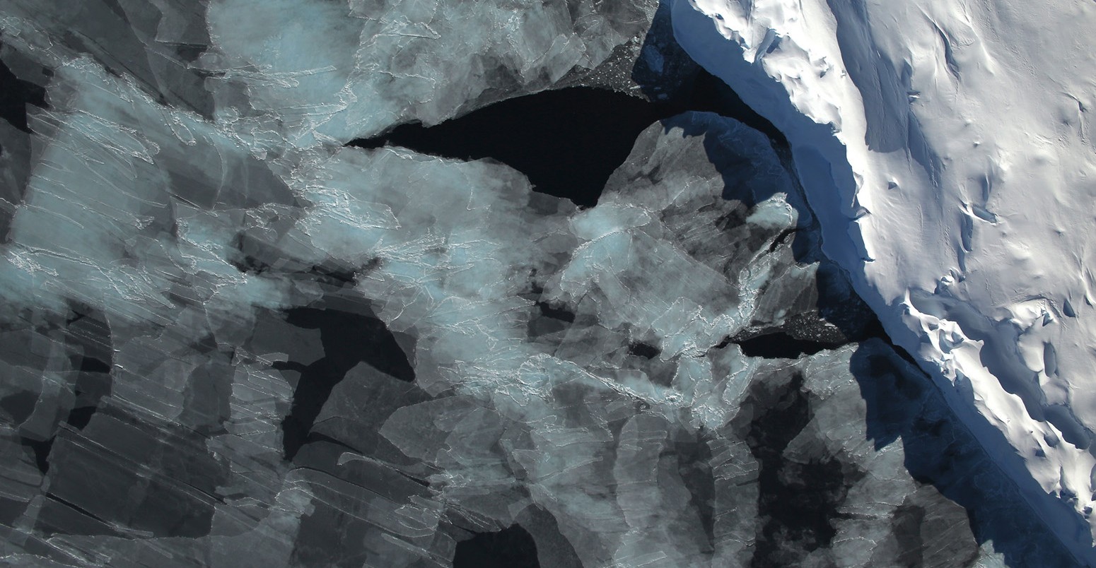 A small hole in the clouds revealed newly formed sea ice in the Bellingshausen Sea next to an ice berg on Nov. 5, 2014 flight