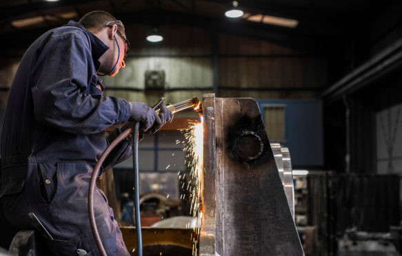 Steel Worker welds component for Oil and Shipping industry in UK Factory, near Aberdeen Scotland. Credit: Scott-Ray Johnson / Alamy Stock Photo DDRN2F