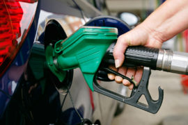 Woman Filling a Car with Unleaded Petrol, UK.