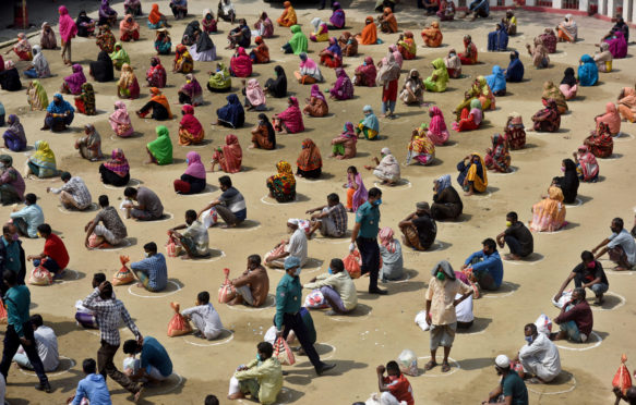 Bangladeshi homeless people wait in a queue for aid during the nationwide coronavirus lockdown. Dhaka, Bangladesh, 4 April 2020. Credit: SK Hasan Ali / Alamy Stock Photo