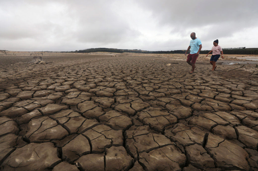 A-family-negotiates-their-way-through-caked-mud-at-Theewaterskloof-dam-at-as-Cape-Town-faces-Day-Zero