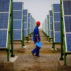 A worker inspects solar panels at a solar farm in Dunhuang