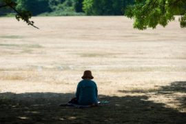 A woman sits in the shade at Primrose Hill during the severe heatwave, London, UK, 19 July 2022. Credit: xStephen Chung / Alamy Stock Photo.