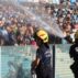 Firefighters spray water at people due to intense heat during a football game in Argentina.