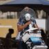 A man carries a fan as temperatures reach 38C in Montpellier, France.