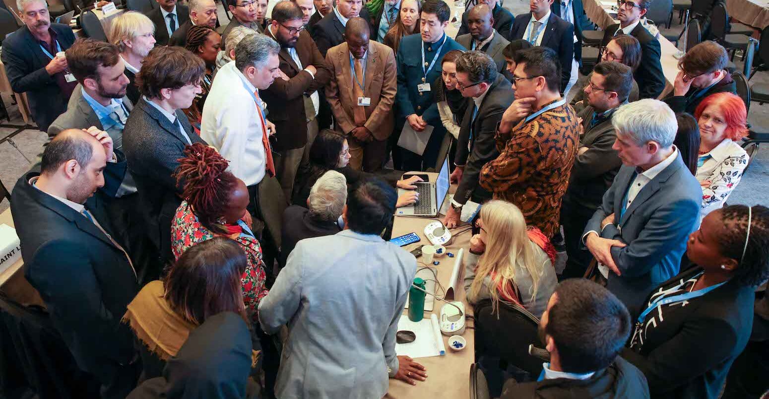 IPCC delegates negotiating in a huddle in Istanbul, Türkiye.