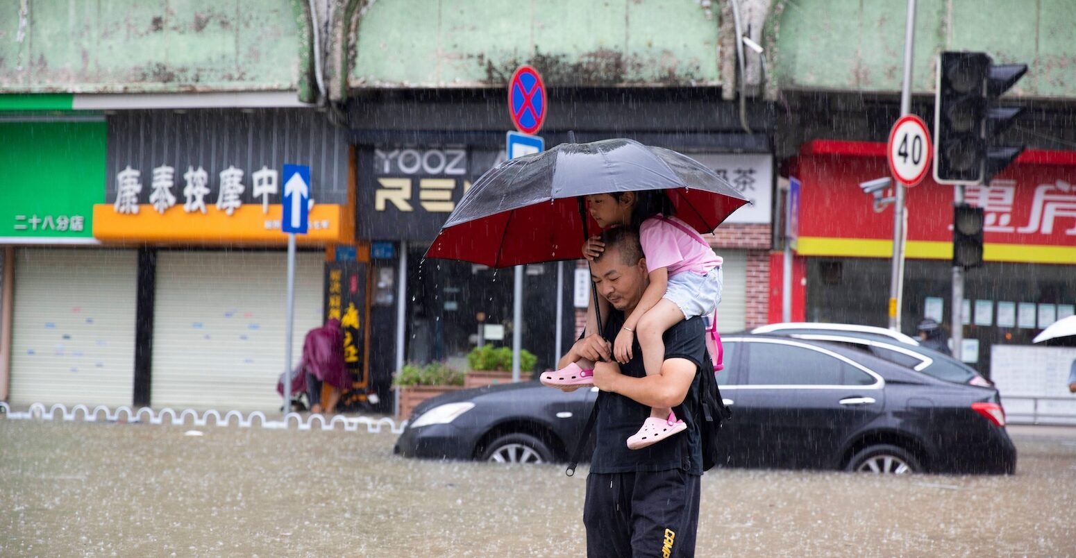 A man carrying a child wades through floodwater in Guangzhou, south China.