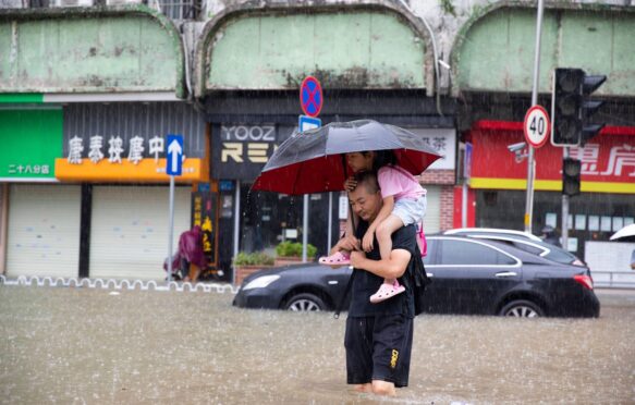 A man carrying a child wades through floodwater in Guangzhou, south China.