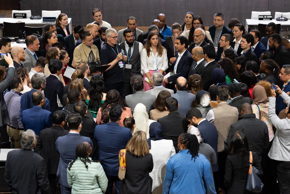 Delegates huddle during informal consultation on the JTWP on 12 June. 