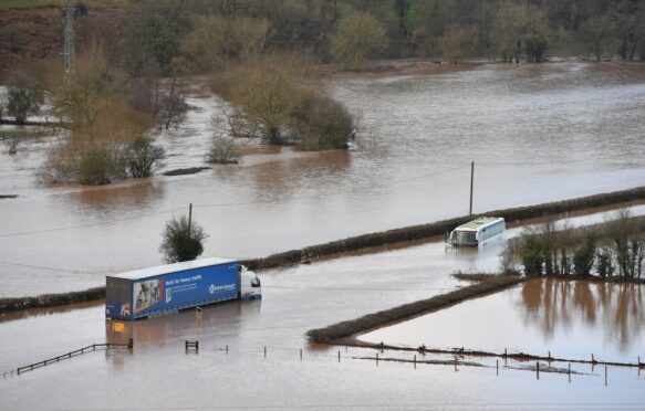 Large vehicles submerged in floodwater, Worcestershire, UK.