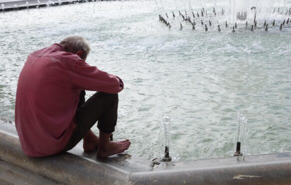 A man tries to keep cool by a fountain during a heatwave in France.