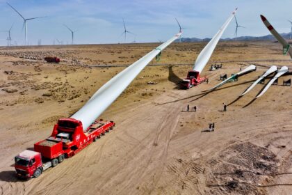 Builders transfer wind turbine blades to a hoisting site at the construction site in Zhangye, China.