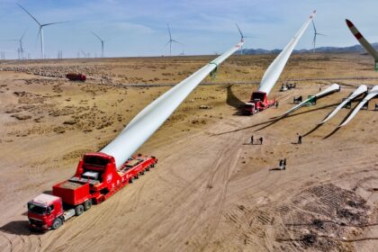 Builders transfer wind turbine blades to a hoisting site at the construction site in Zhangye, China. Credit: Sipa US / Alamy Stock Photo. Image ID: 2PHDHEH.