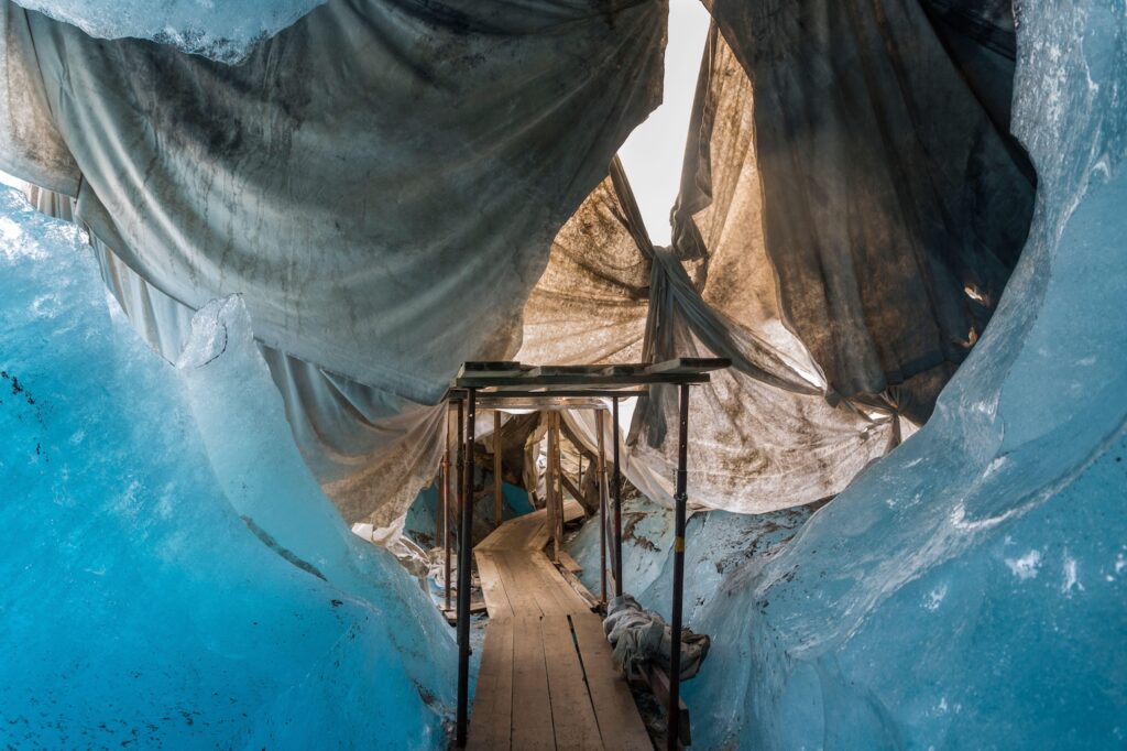 Ice cave of the Rhone glacier in Switzerland, covered with white tarpaulins to protect against melting.