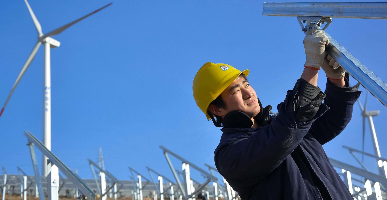 A worker installs solar panels at a photovoltaic power station in Luoyang city, China.